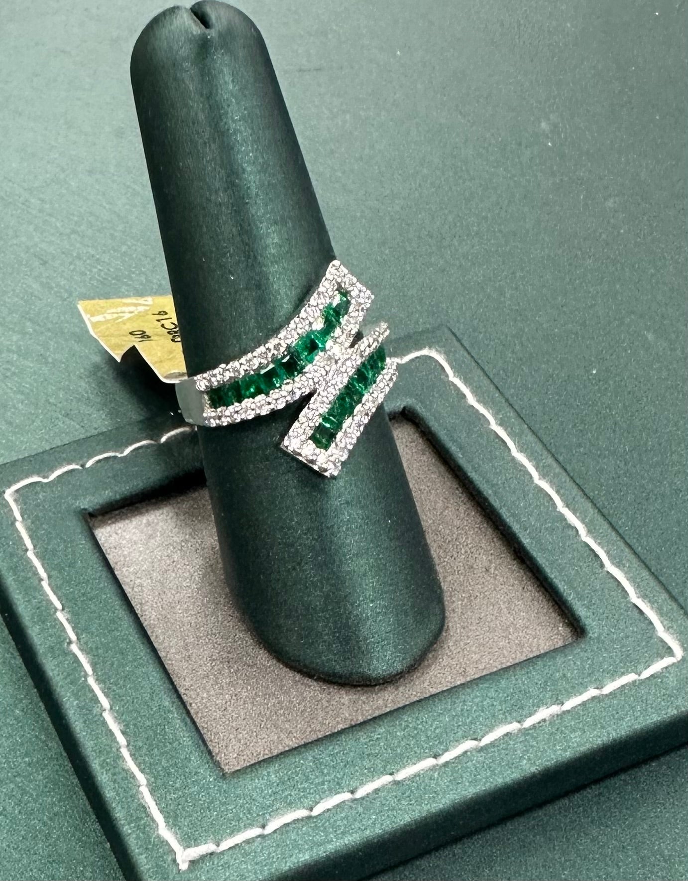 Twisting row emerald and diamond ring